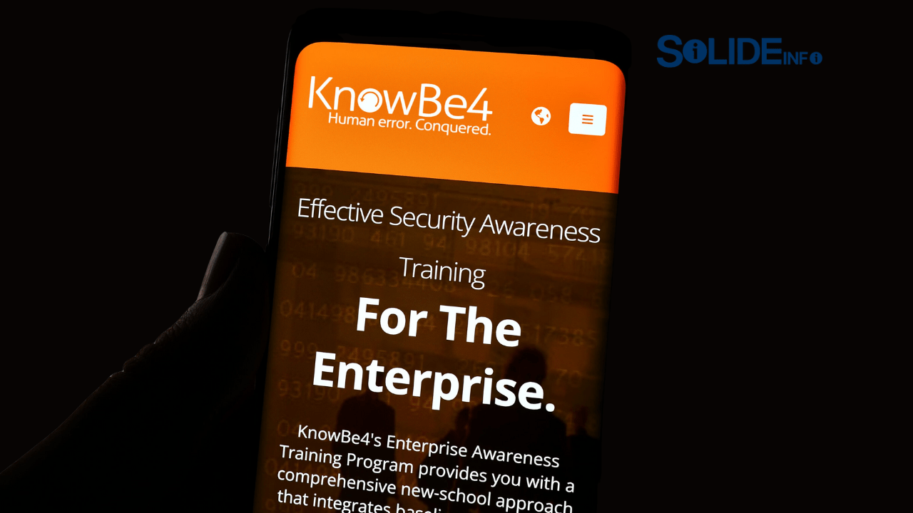 A group of diverse employees looking at a monitor with a lock icon, representing the importance of security awareness and a focus on KnowBe4 training.